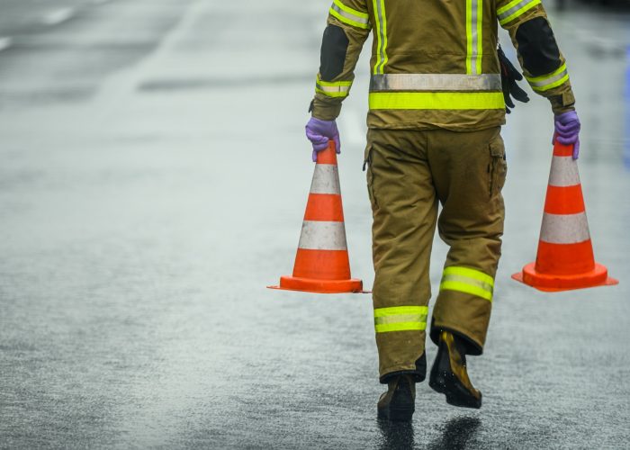 Highway Worker Preparing For Road Closure Moving Two Traffic Cones